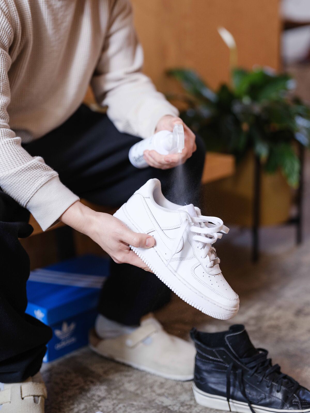 Man spraying Jason Markk Refresh Spray into a pair of Nike Air Force 1s to instantly neutralize any odors.