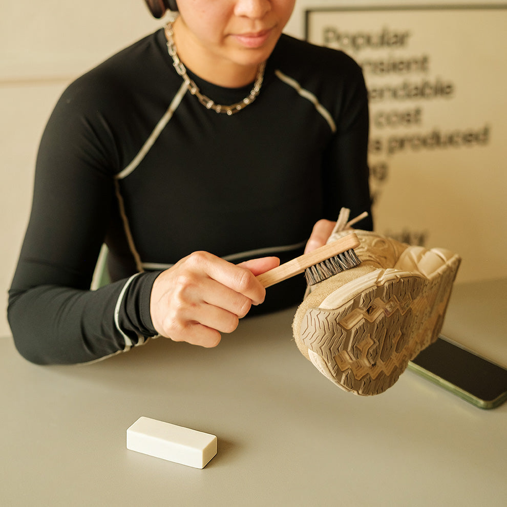 Person using Suede Brush and Eraser on a pair of Suede Running shoes.