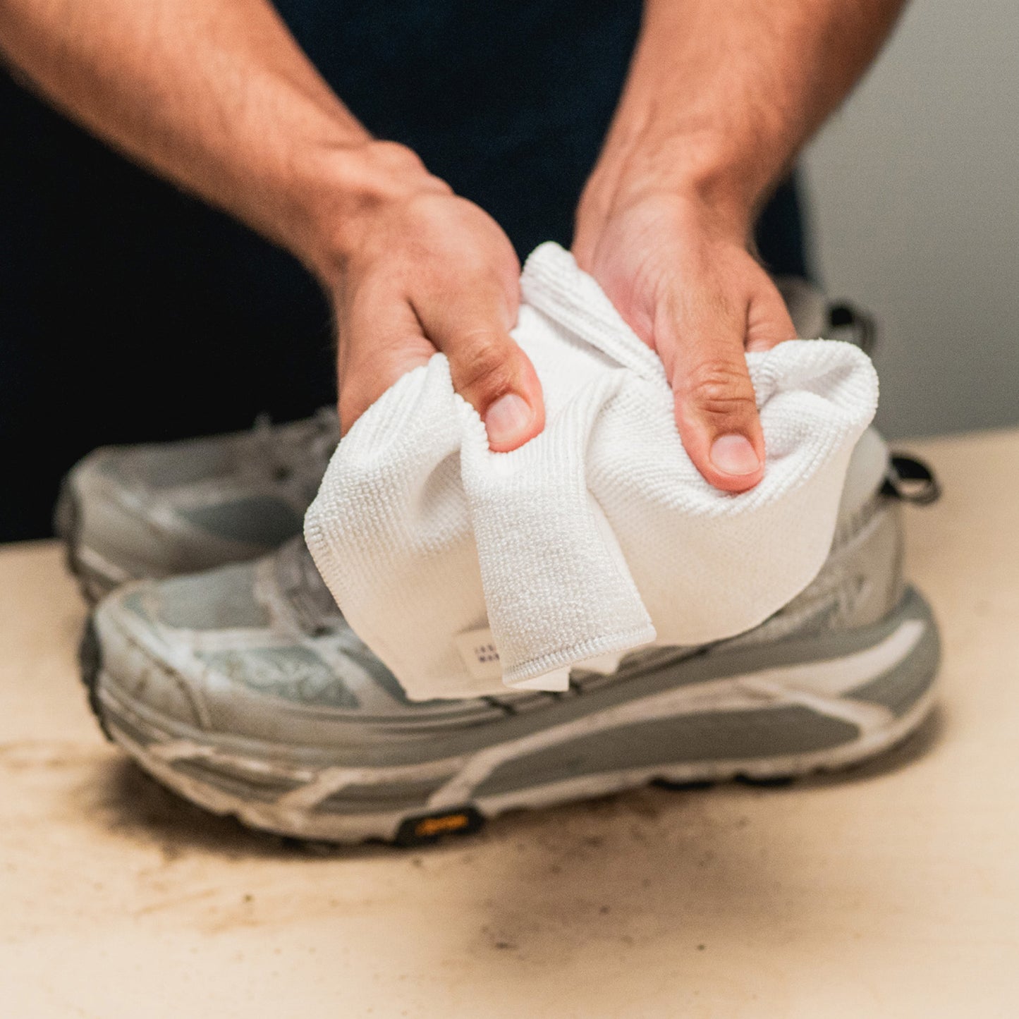 A JASON MARKK MICROFIBER TOWEL HELD DISPLAYING THE TEXTURE AND DURABILITY