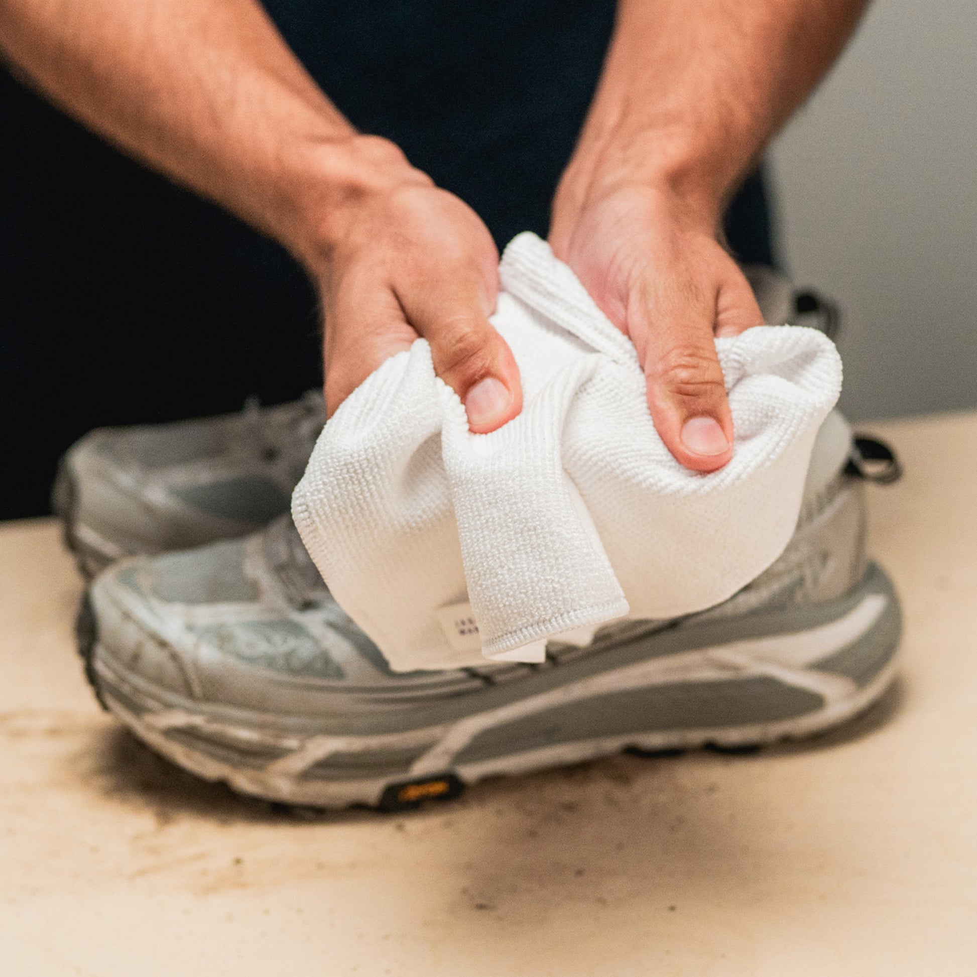 A JASON MARKK MICROFIBER TOWEL HELD DISPLAYING THE TEXTURE AND DURABILITY
