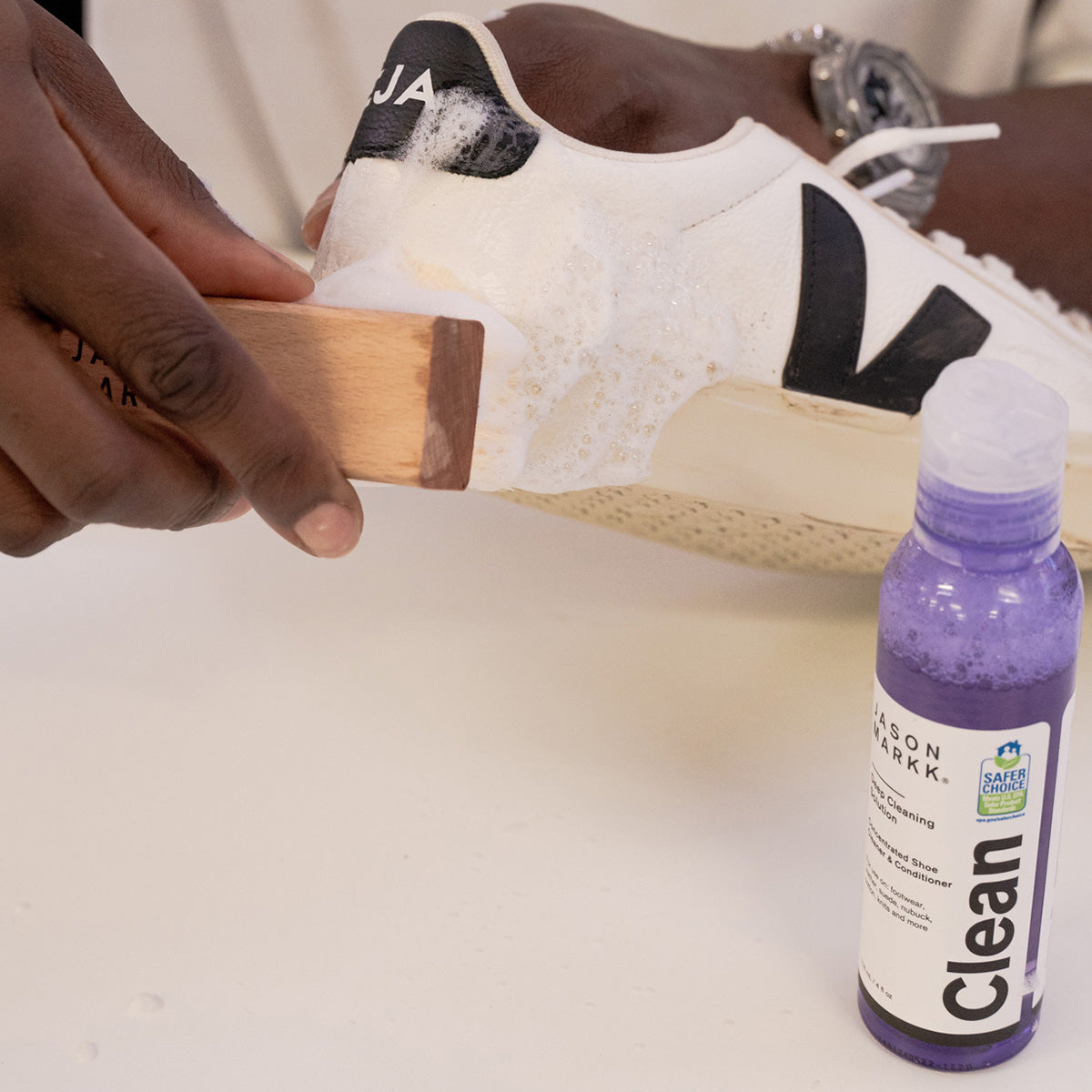 A photo showing a man cleaning Veja shoes with Jason Markk Essentials Kit