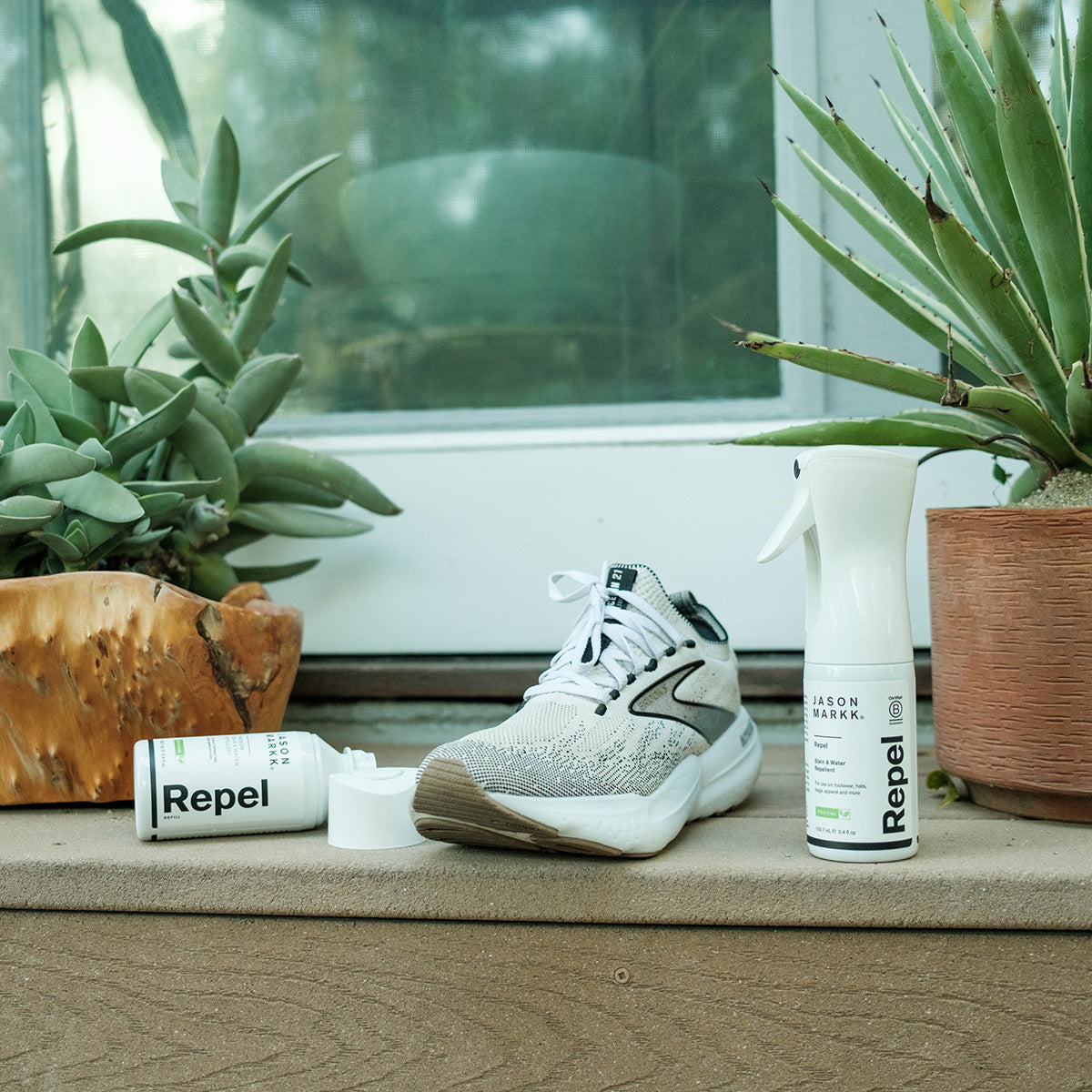Jason Markk Repel Spray and Refill sitting next to a Brooks Running shoe.