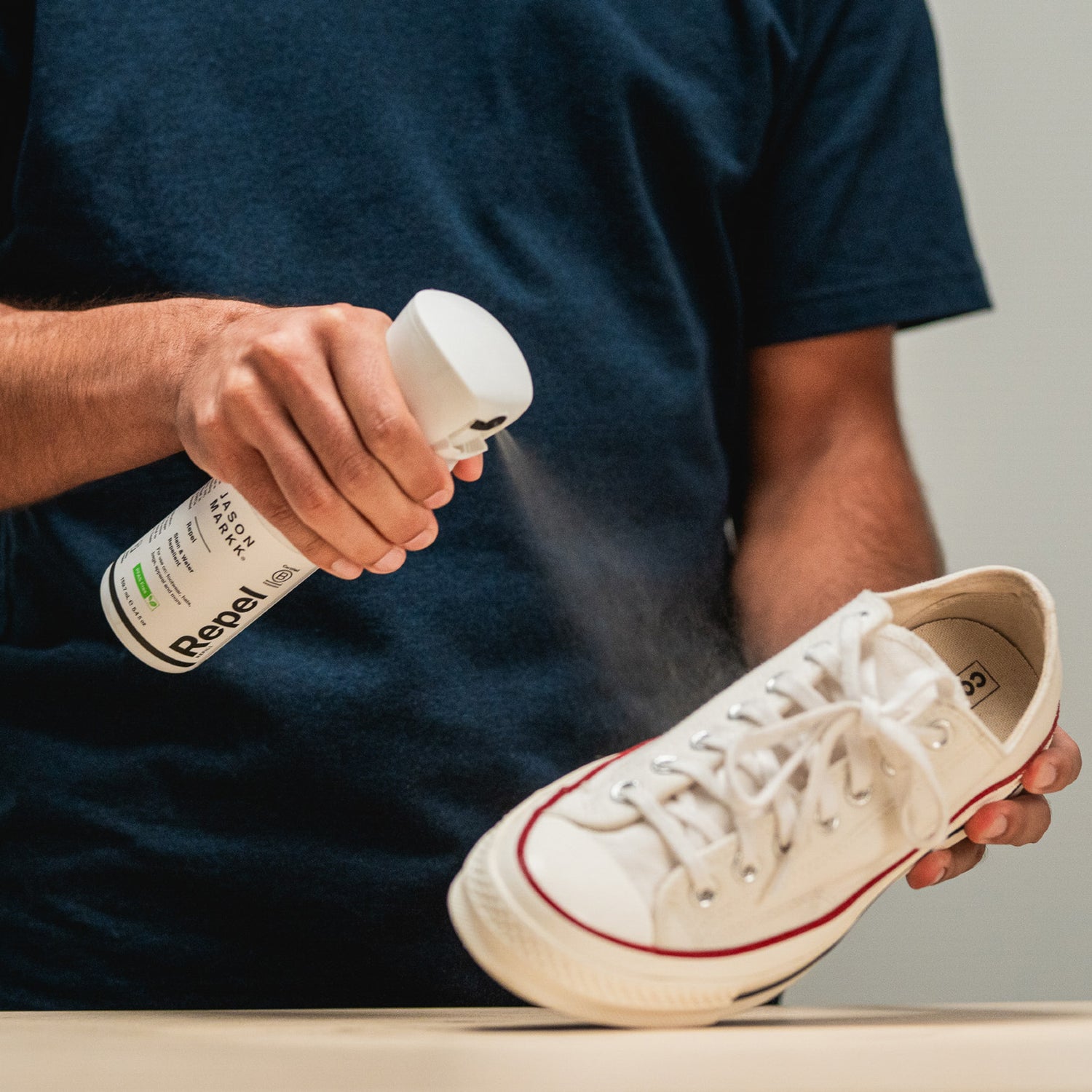 JASON MARKK REPEL SPRAY BEING APPLYED ON A PAIR OF WHITE CONVERSE CHUCK TAYLOR LOW 1970