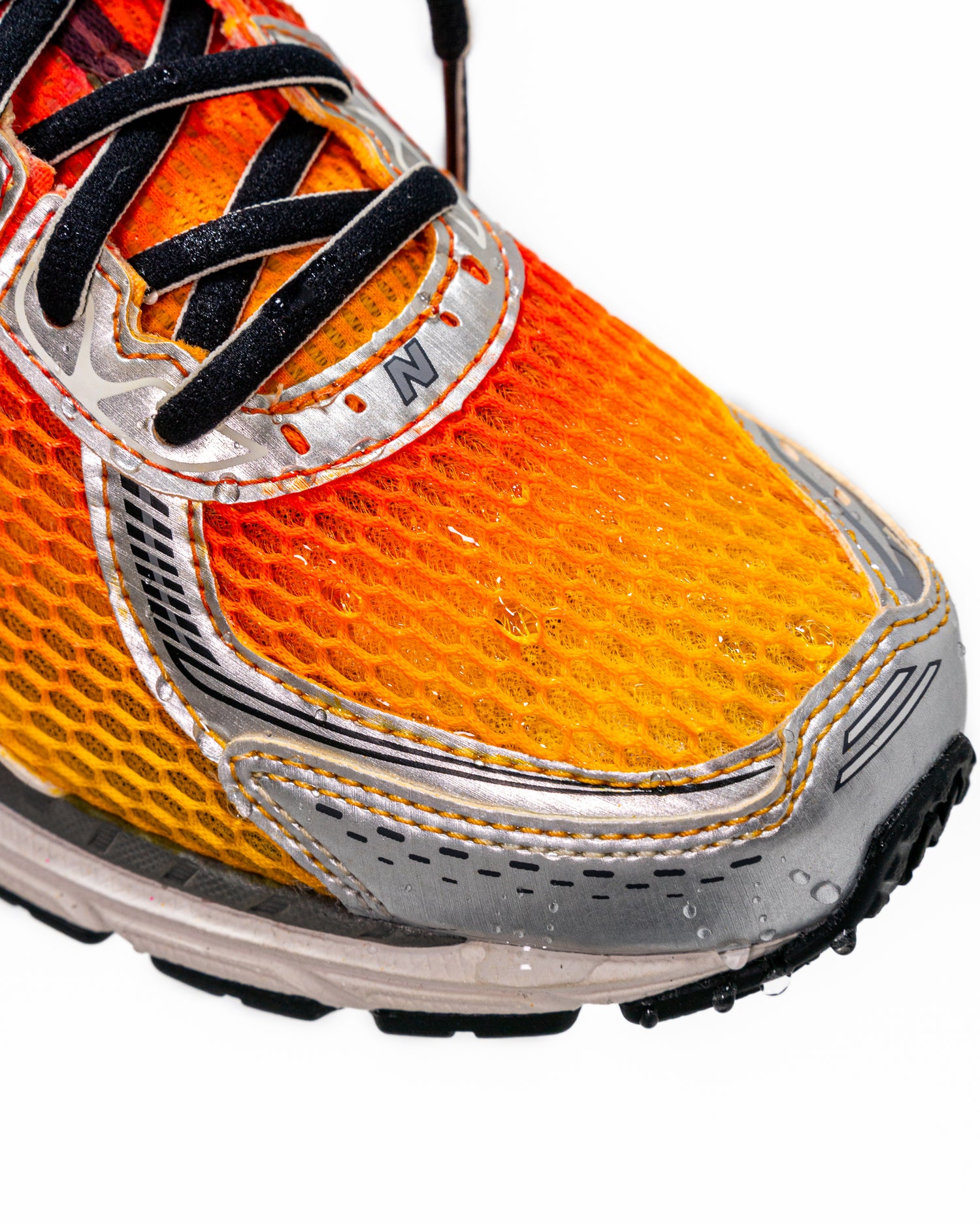 Photo showing the effects of Jason Markk Repel Spray on a shoe. The water is visibly beading off of the front of the shoe.