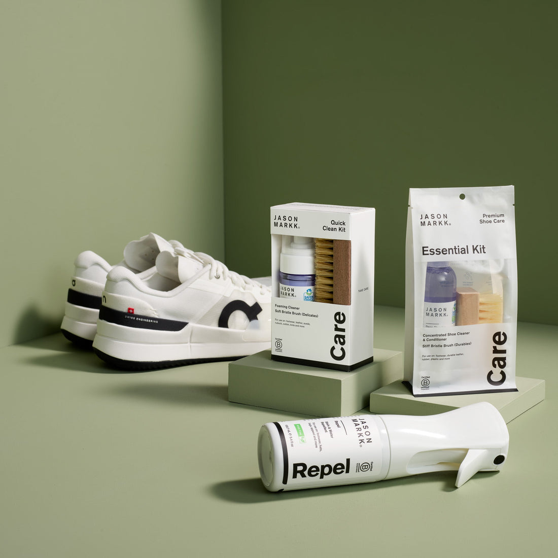 Jason Markk Quick Clean Kit, Essential Kit and Repel Spray next to a pair of white sneakers