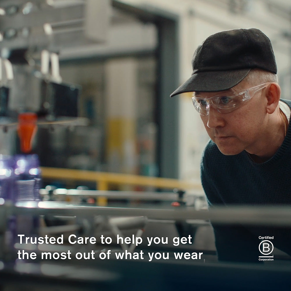 Jason Markk wearing safety glasses and a hat in the company factory with text about Trusted Care.