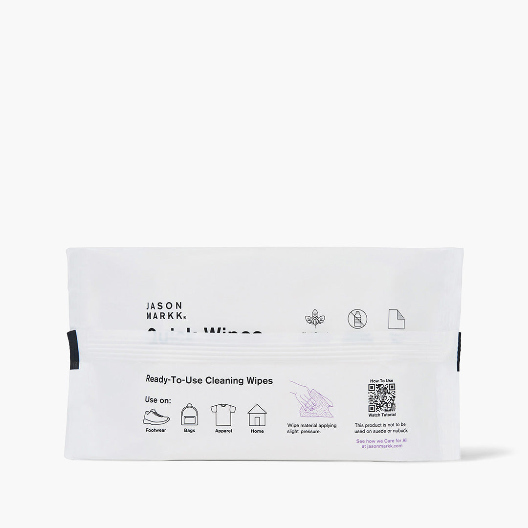 Jason Markk Essential 30pk Quick Wipes back panel. Use on: Footwear, Bags, Apparel, Home. Instructions: Wipe material applying slight pressure. Not for use on suede or nubuck. Icons for plant-based, no water needed, and single-use. QR code links to how-to tutorial at jasonmarkk.com. See how we Care for All at jasonmarkk.com. White pouch, white background.