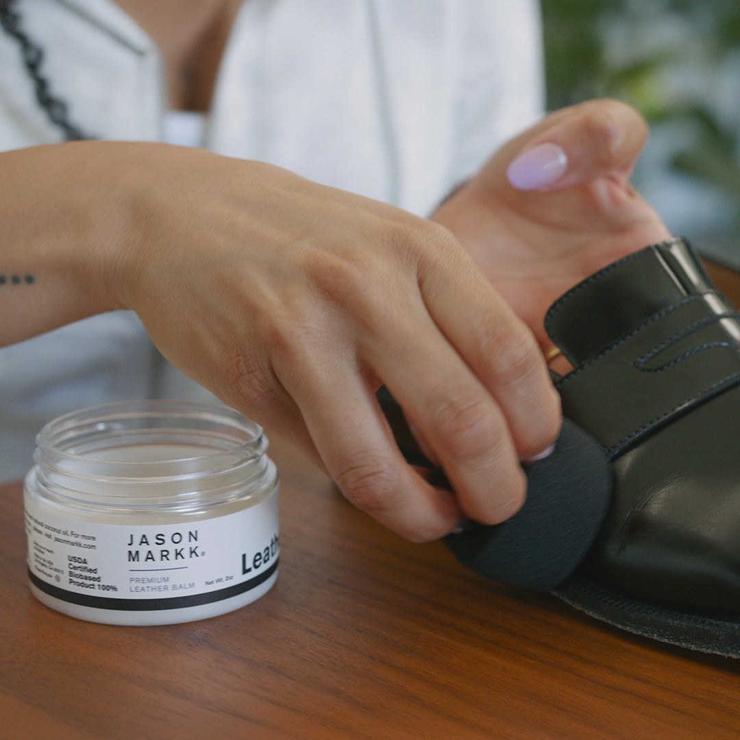 Woman cleaning loafers with Premium Leather Balm.
