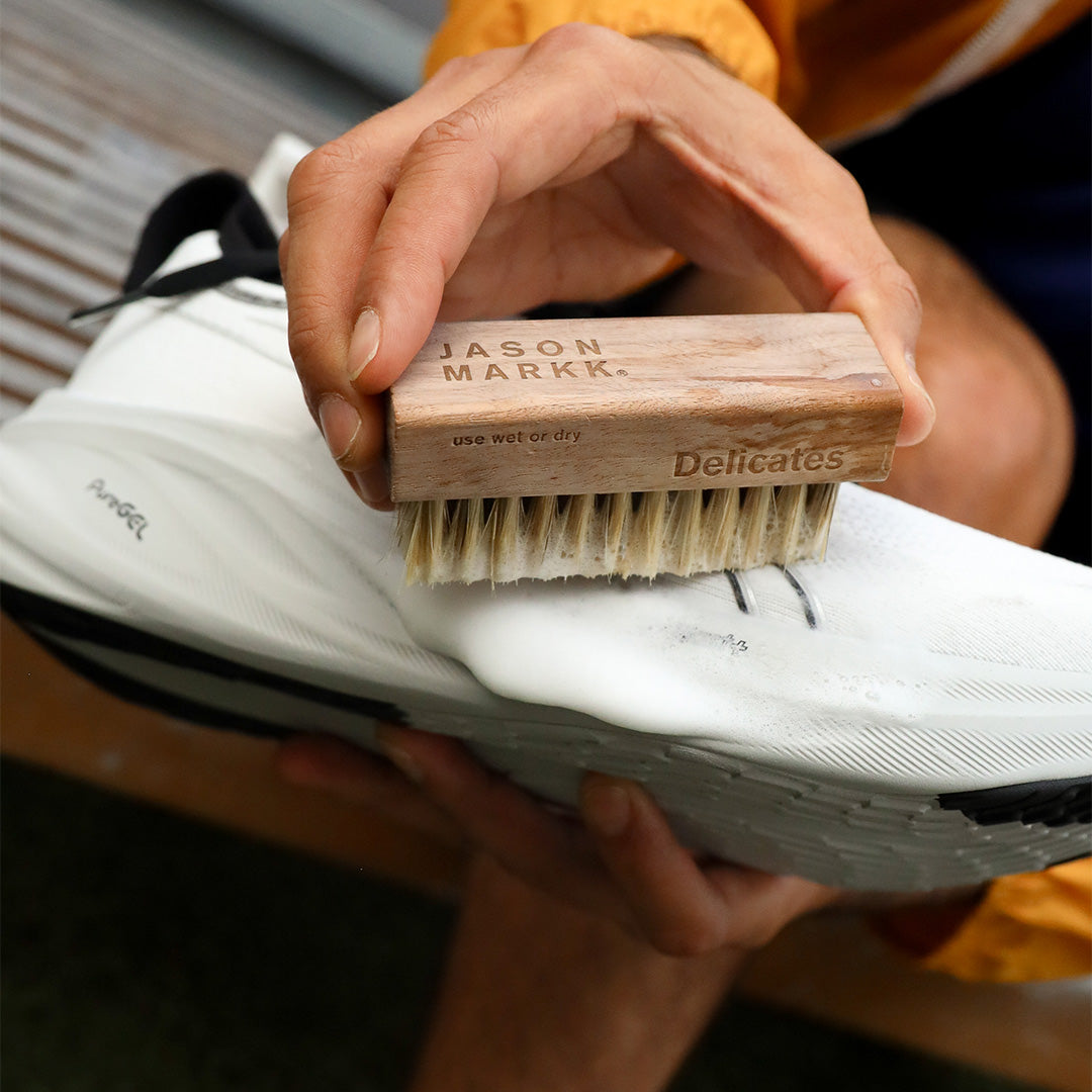 Person cleaning a running shoe with the Delicates Brush