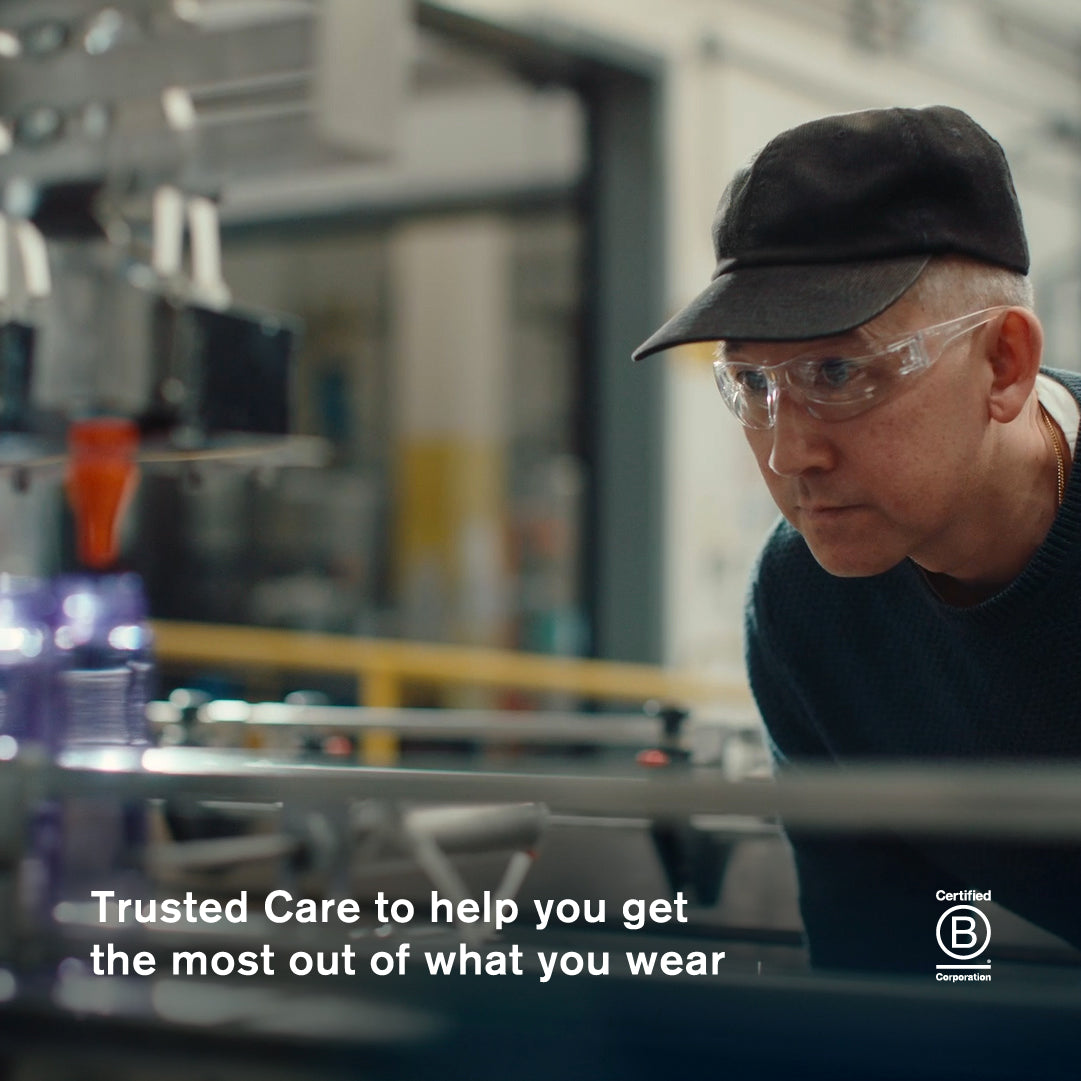 Jason Markk wearing safety glasses and a hat in the company factory with text about Trusted Care.