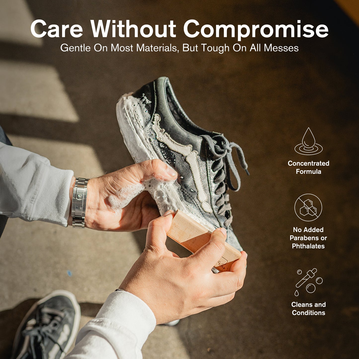 Hands scrubbing a dirty gray sneaker with a brush and foamy Jason Markk Concentrated Shoe Cleaner. Text reads: "Care Without Compromise — Gentle On Most Materials, But Tough On All Messes." Icons highlight: Concentrated Formula, No Added Parabens or Phthalates, Cleans and Conditions.