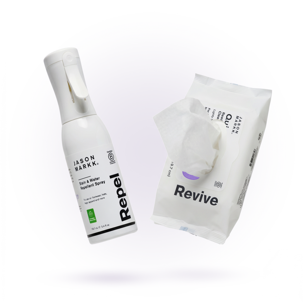 Jason Markk Anti-Stain Bundle on a transparent background. A white "Stain & Water Repellent Spray, Repel, 159.7 mL / 5.4 fl oz, For use on: footwear, hats, bags, apparel and more, Formulated Without PFAS" bottle sits at an angle beside an open "Jason Markk Quick Wipes Essential 30 pack, Ready-To-Use Cleaning Wipes, Lightly Scented" resealable pack with a wipe pulled out. Both feature Certified B Corporation logos.