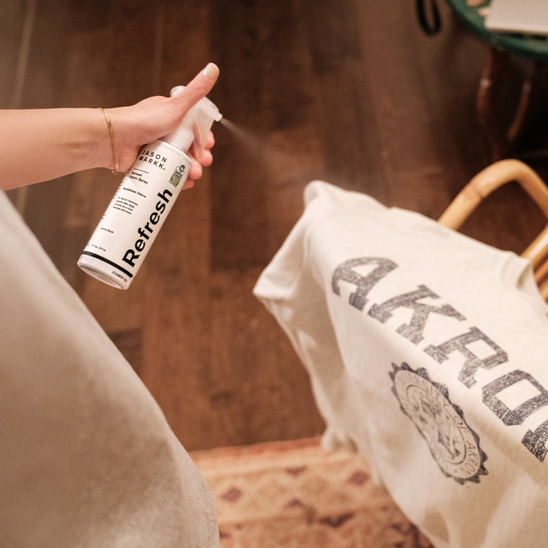 Person spraying a sweatshirt with Refresh