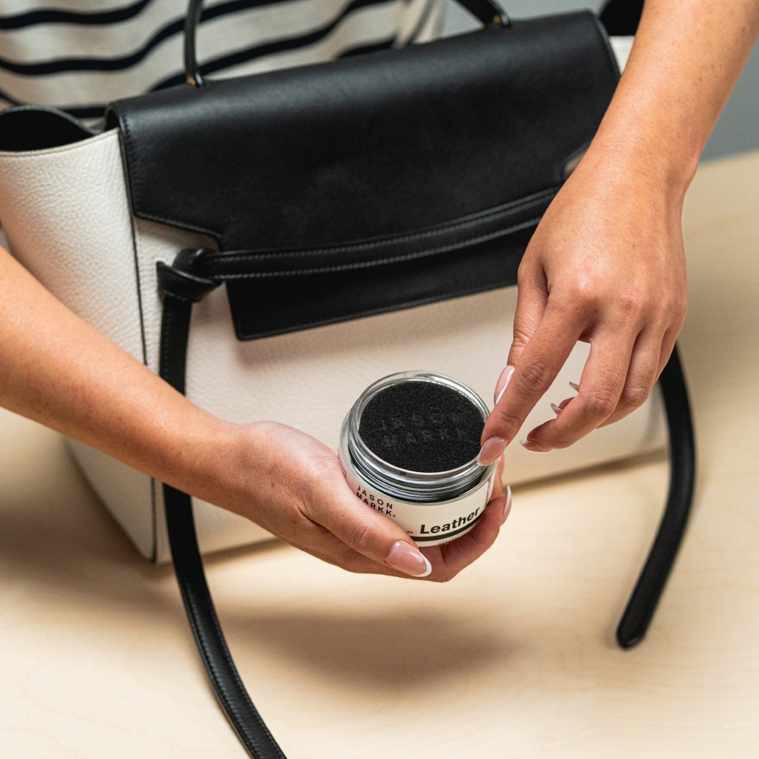 JASON MARKK LEATHER BALM SHOWN INFRONT OF A CELINE HAND BAG