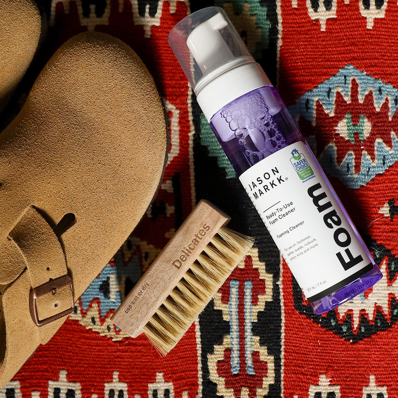 Jason Markk RTU Foam and a Delicate Brush on a patterned rug next to a Birkenstock Boston.