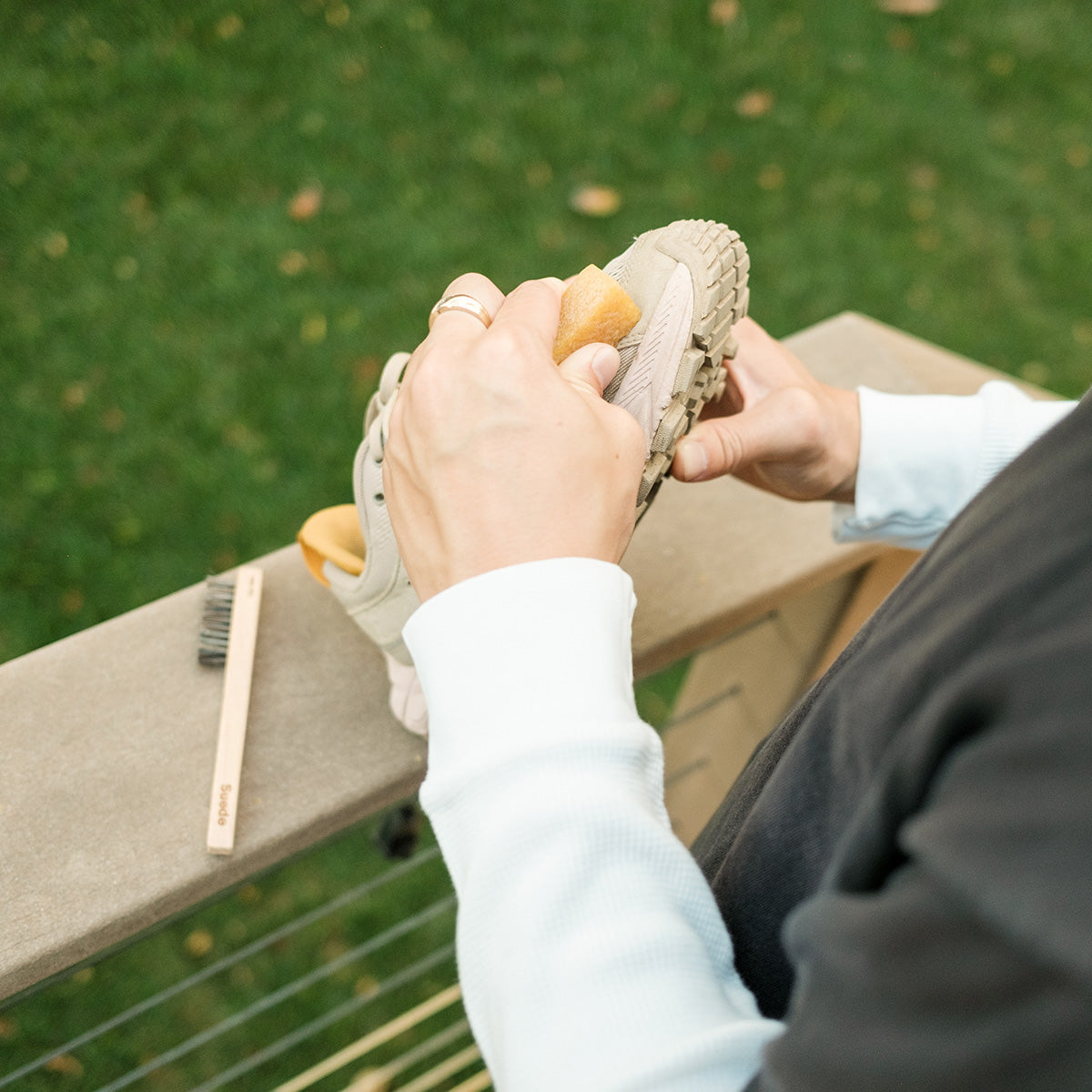 Man using Suede eraser on shoes with the Suede brush laying in the background
