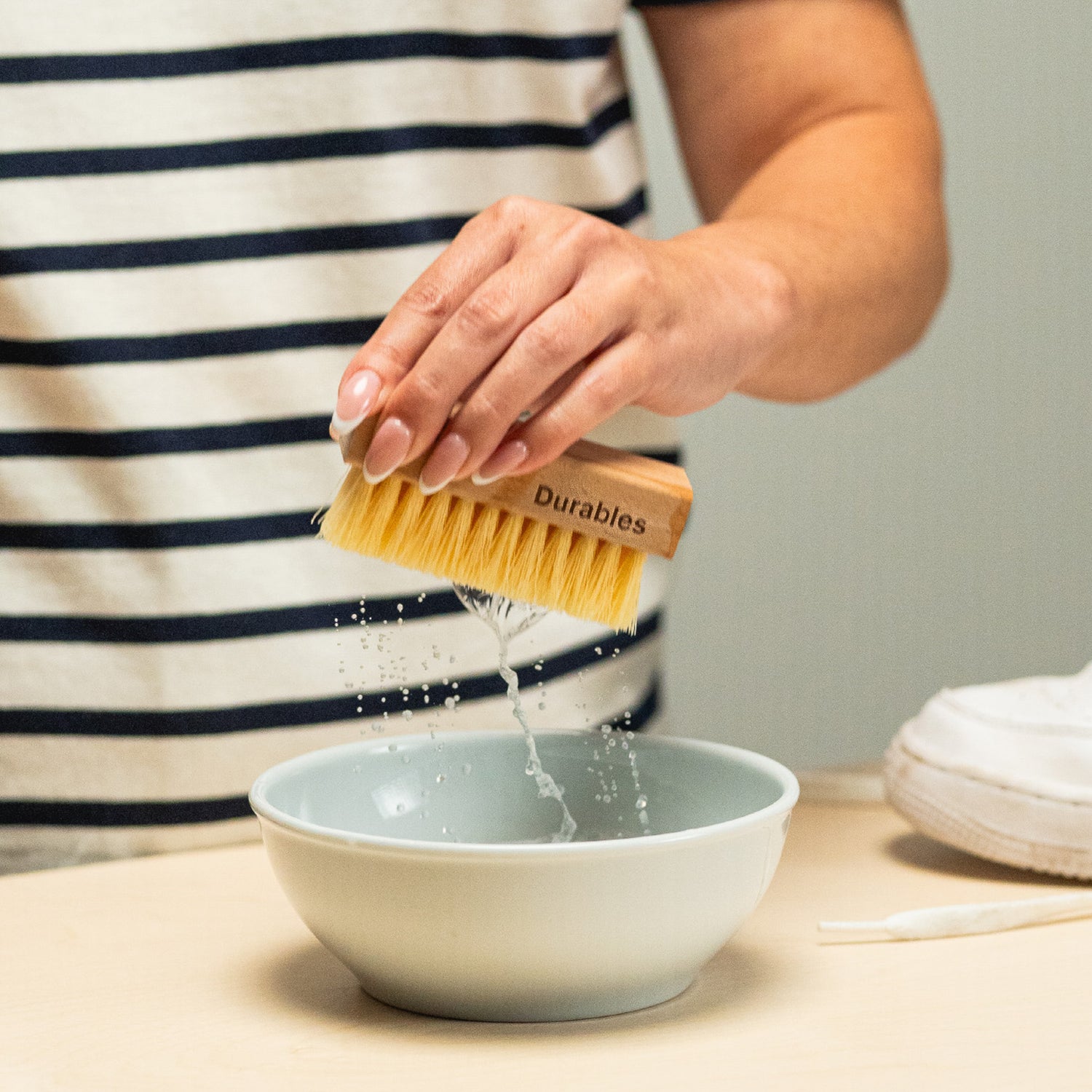 SHAKING A JASON MARKK DURABLES BRUSH IN A BOWL TO REMOVE EXCESS LIQUID FROM BRUSH