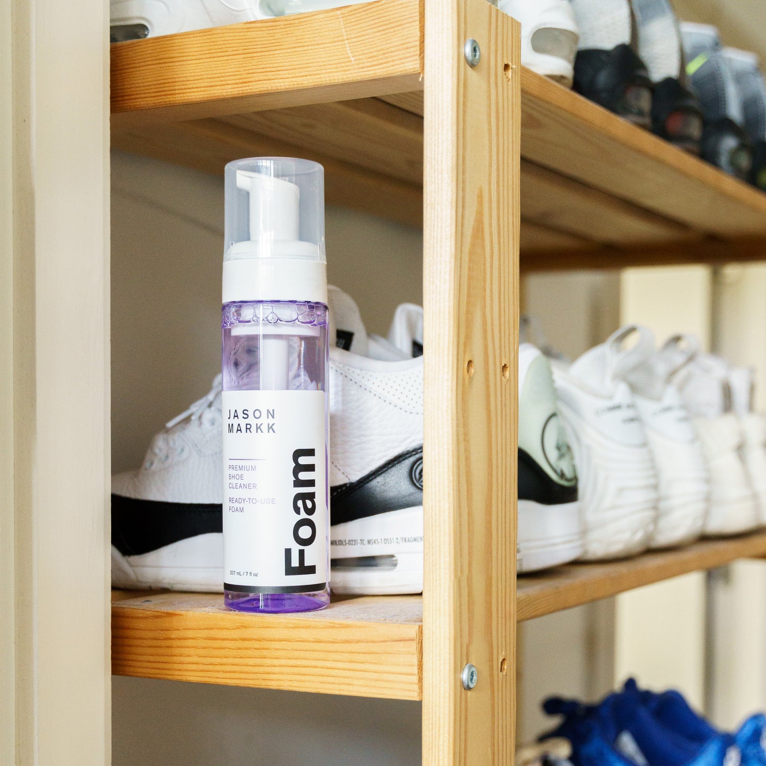 A JASON MARKK CARE KIT ON A SHOE SHELF WITH OTHER VARIOUS SHOES