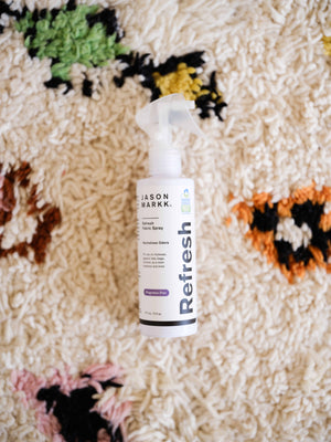 Bottle of Jason Markk Refresh on a textured surface