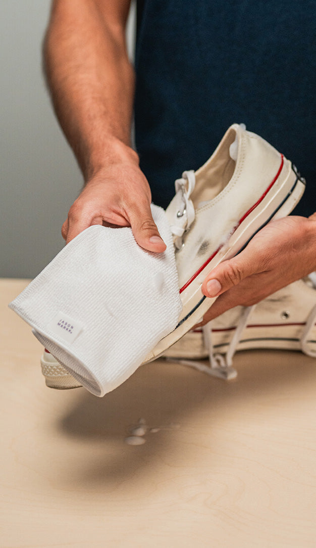 JASON MARKK MICROFIBER TOWEL WIPING A PAIR OF CONVERSE CHUCK TAYLOR LOW 1970 