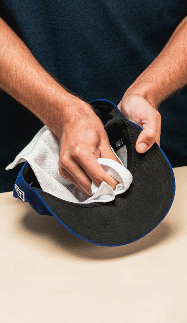 JASON MARKK MICROFIBER TOWEL WIPING A NEW ERA DODGER HAT