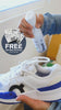 A hand sprays Jason Markk "Repel Stain & Water Repellent Spray" onto white and blue On sneakers indoors near a bright window. A navy "FREE Gift With Purchase Of Any Bundle" badge sits at left, featuring "Jason Markk Shoe Cleaning Wipe, Quick Wipes" packets. The bottle reads "Jason Markk, Stain & Water Repellent Spray, Repel" with a Certified B Corporation logo.
